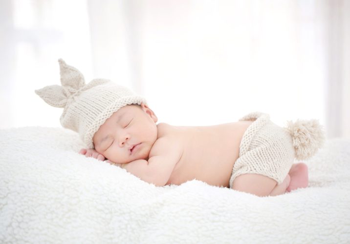 Lovely newborn Asian baby sleeping on furry cloth